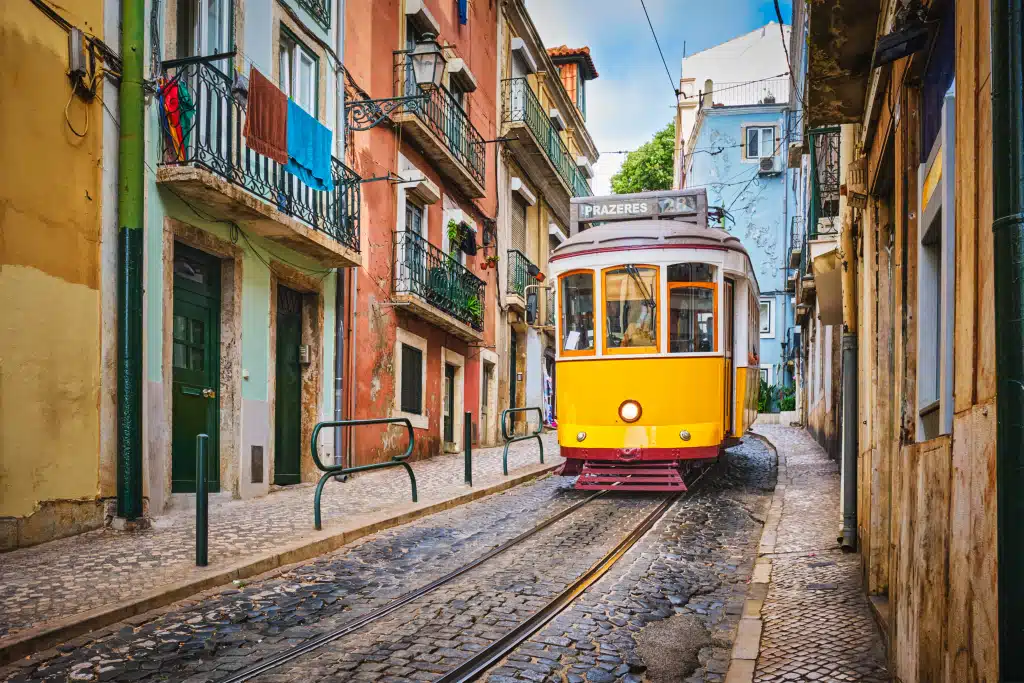 Famous vintage yellow tram 28 in the narrow streets of Alfama district in Lisbon Portugal Ramos Pinto High End Relocation Team